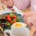 Enjoy a nutritious breakfast with greens, fried egg, and fresh orange juice for a healthy start to your day.